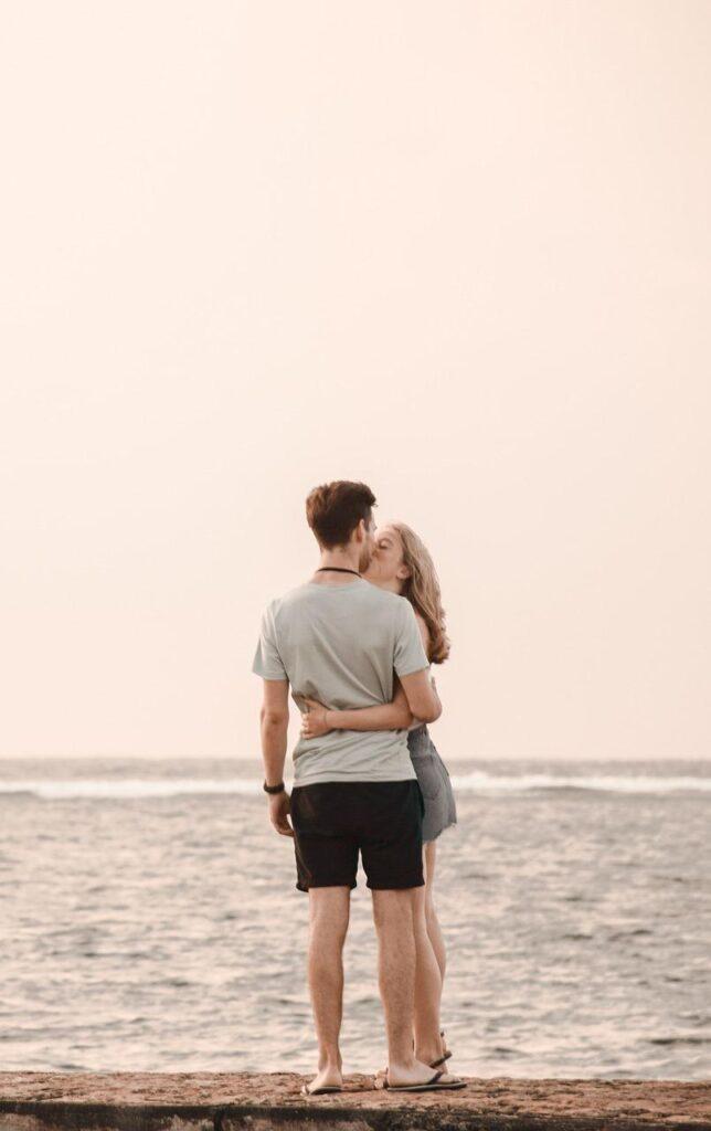 Pareja de novios disfrutando del atardecer en la playa